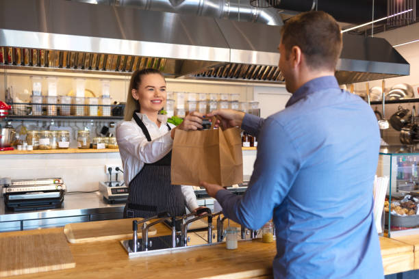 Happy waitress waring apron serving customer