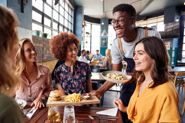 Waiter Serving Group Of Female Friends Meeting For Drinks And Food fenton mi 48430