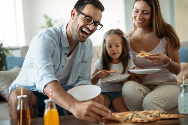 Portrait of happy family sharing pizza together at home at fenton mi 48430