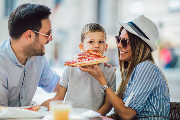 Portrait of happy family spending time in pizzeria at fenton mi 48430