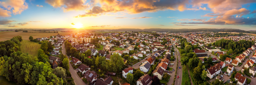 Aerial panorama of a small town at sunrise, with magnificent colorful sky and warm light