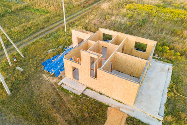 Construction of new and modern modular house. Walls made from composite wooden sip panels with styrofoam insulation inside. Building new frame of energy efficient home concept.