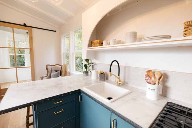 Interior Decor shot of Tiny House on a trailer, featuring a small space kitchen, bedroom, and bathroom.